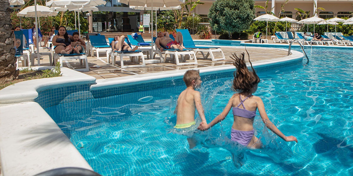 Dos niños saltando a la piscina