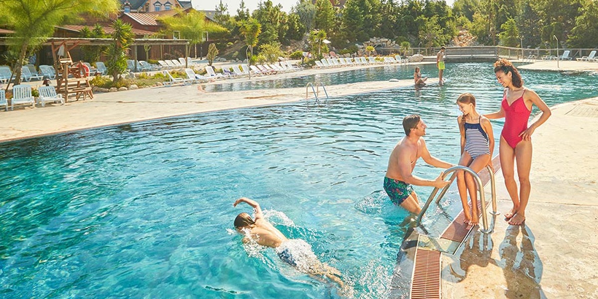 Familia en la piscina de un hotel.